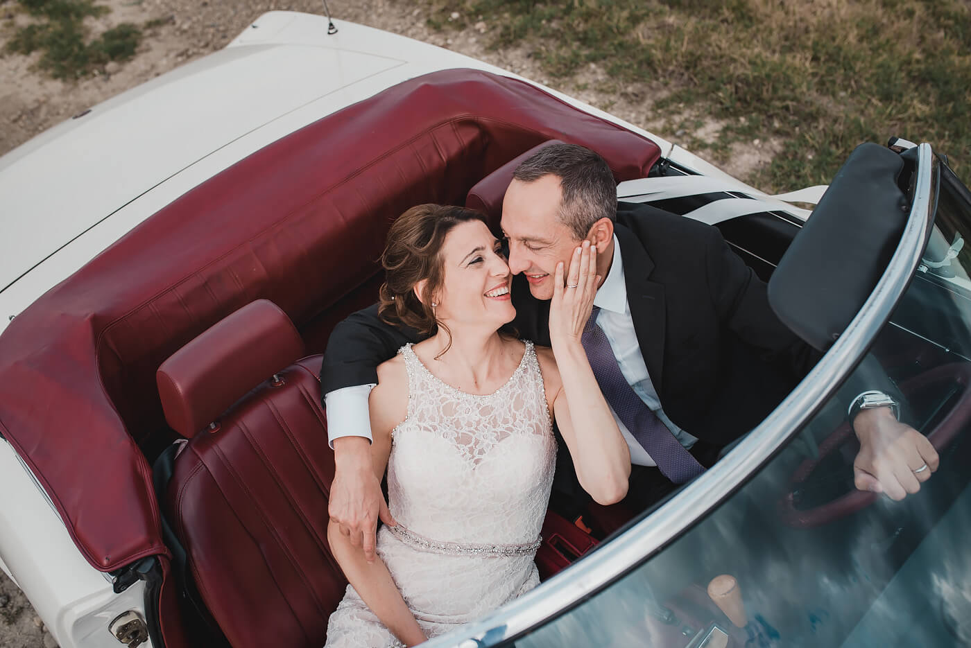 Fotografo di matrimonio Asti sposi che si abbracciano in una fiat spider cabriolet sulle colline di Zonin a Calliano