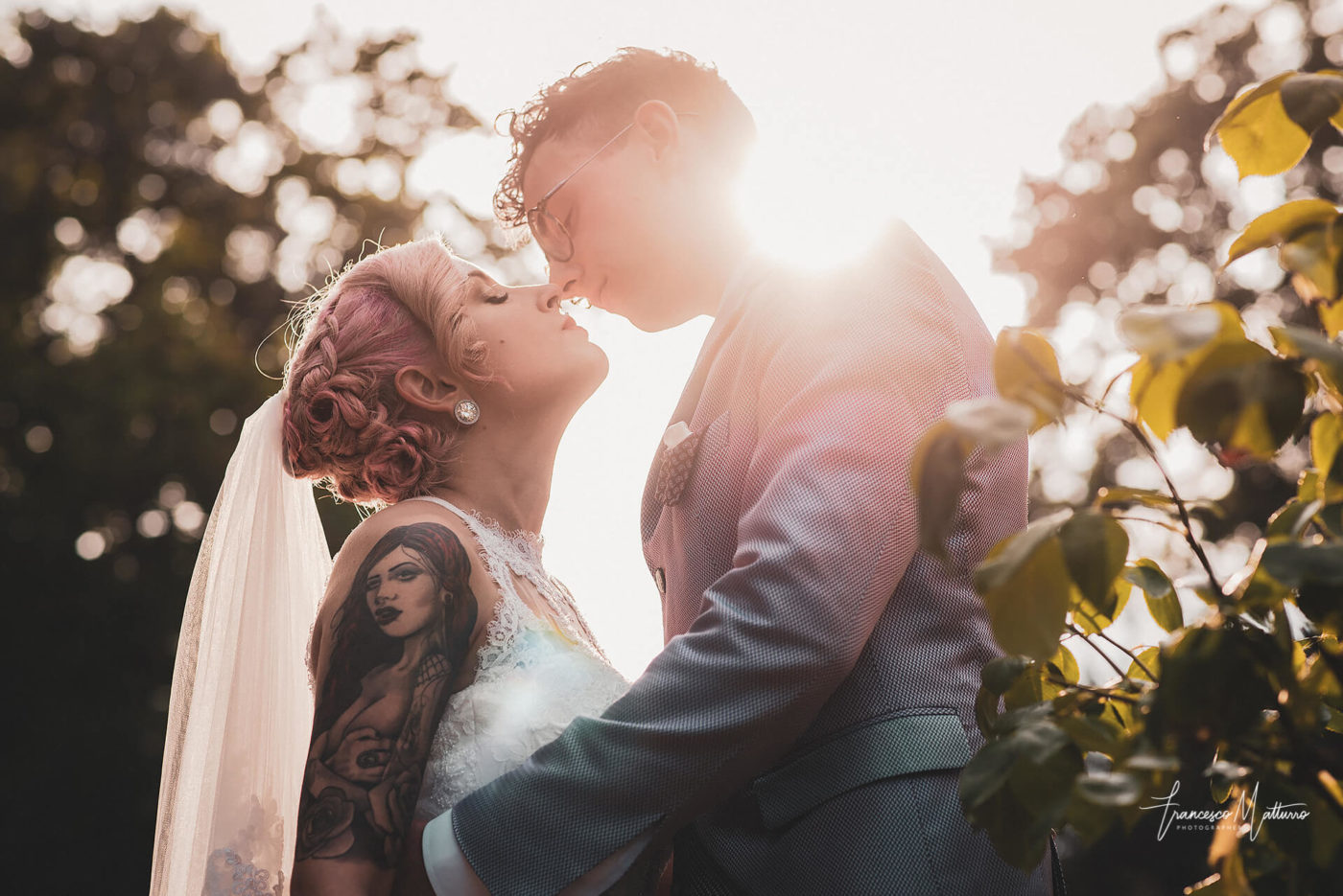 foto di coppia di sposi che si baciano al tramonto nel giardino del parco del castello rosso di costigliole saluzzo di Francesco Matturro